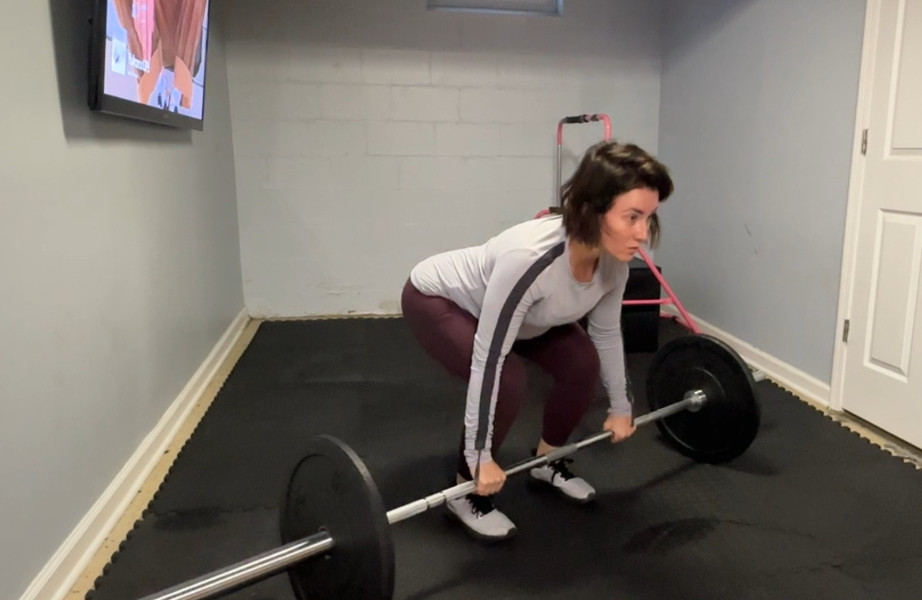 A woman deadlifting the Bells of Steel Olympic Barbell 2.0