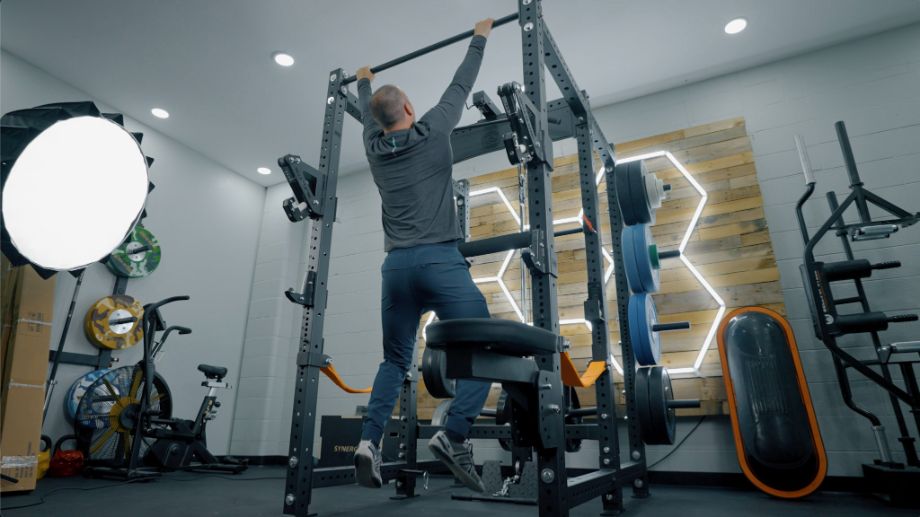 Man performing pull-ups on the Bells of Steel Hydra rack in a garage gym