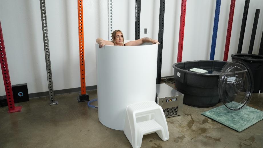 A full view of The Cold Life Plunge with a woman using it.