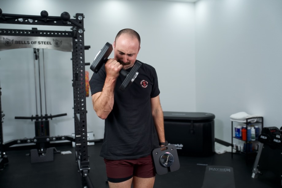 Coop does some bicep curls to prep for the Eisenlink Adjustable Dumbbell Review.
