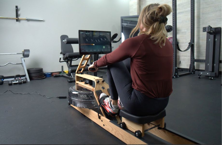 View from behind of a blonde woman following a game-based workout on the Ergatta Lite rower