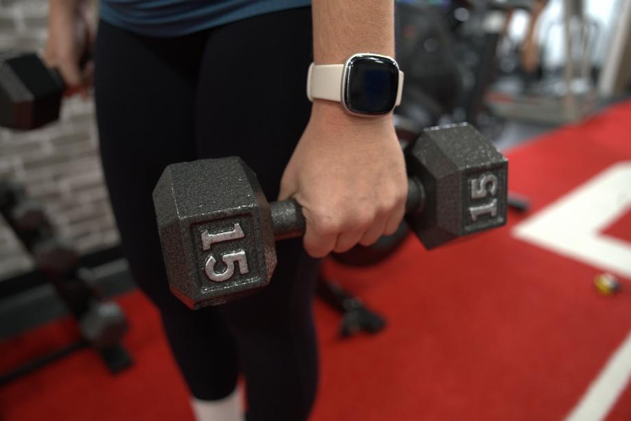 A close look at a person's hand holding a 15-pound Cap Iron Hex Dumbbell.