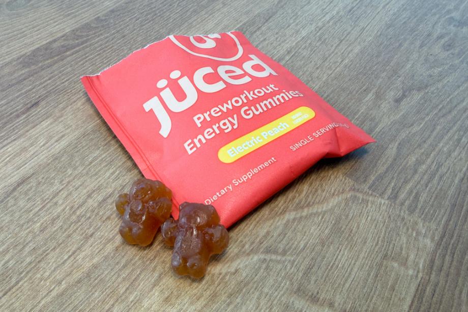 A packet and two gummies of Juced Pre-Workout Energy Gummies sits on a table