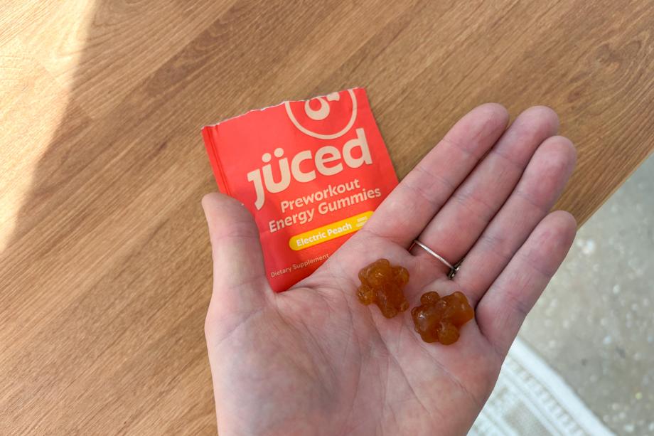A person holding two of the Juced Pre-Workout Energy Gummies