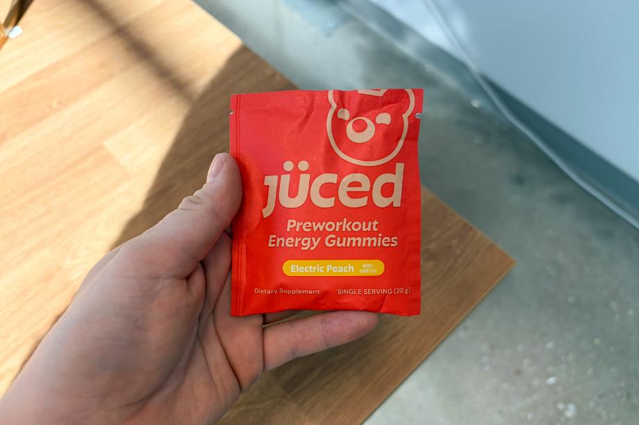 A person holding the single-serving packet of Juced Pre-Workout Energy Gummies