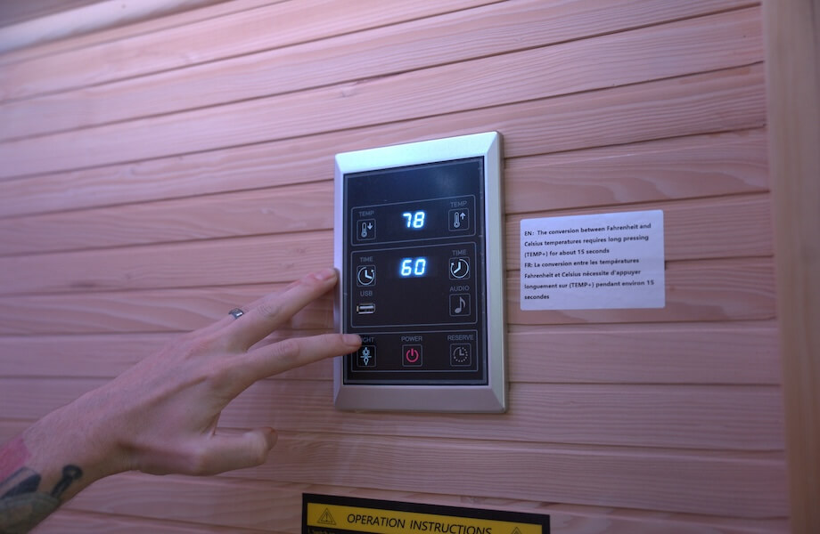 Our tester adjusting the temperate and time controls of the the Relaxe Caldera Infrared Sauna