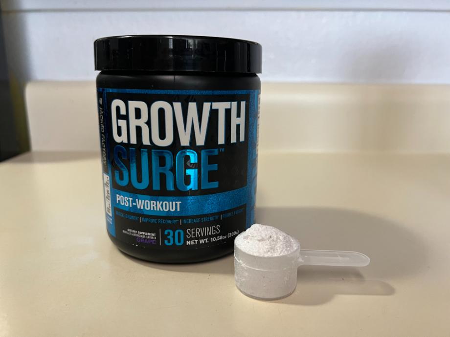 A full scoop of Jacked Factory Growth Surge rests next to the container.