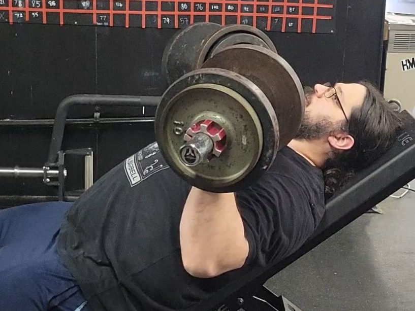 A man performing incline press with the Titan Loadable Dumbbells
