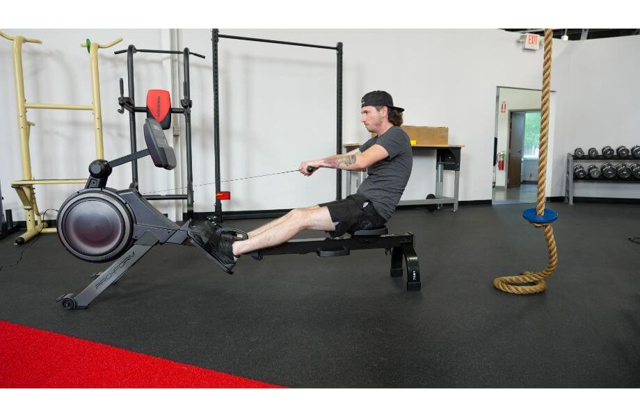A man in a gym setting using a Proform 750r rower