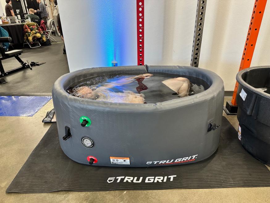 Person fully submerged in an inflatable cold plunge tub