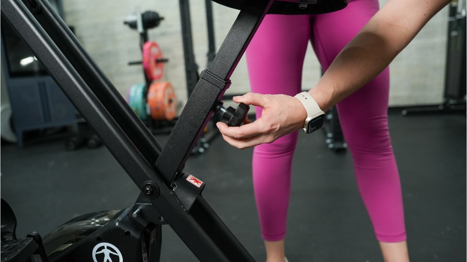 GGR Everything lead reviewer Lindsay Scheele adjusting the seat height on the Marcy Fitness Upright Foldable Exercise Bike