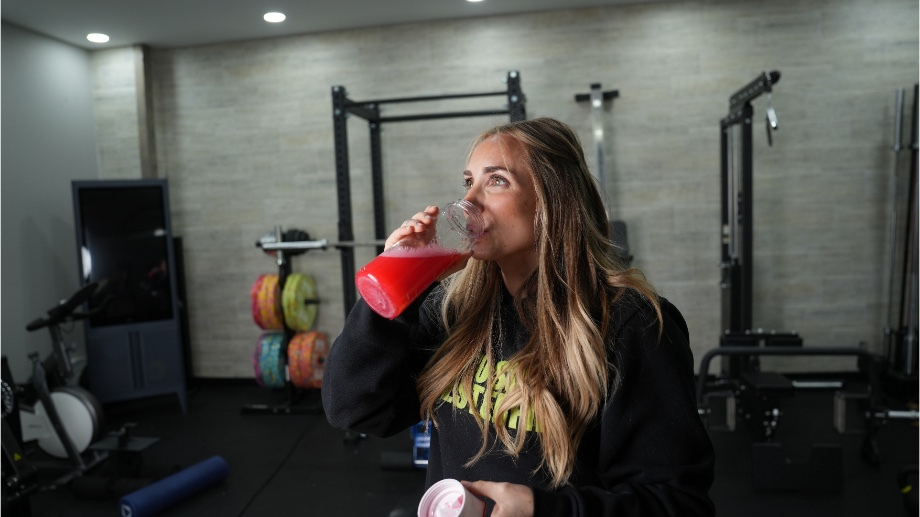 A woman tastes Optimum Nutrition Gold Standard Pre-Workout