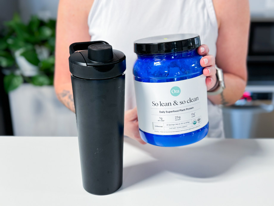 Our tester holds up a container of Ora Organics So Lean & So Clean Plant Based Superfood Protein