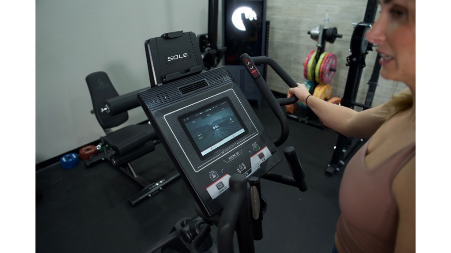 A close-up view of a person holding the handlebar on a Sole E35 elliptical