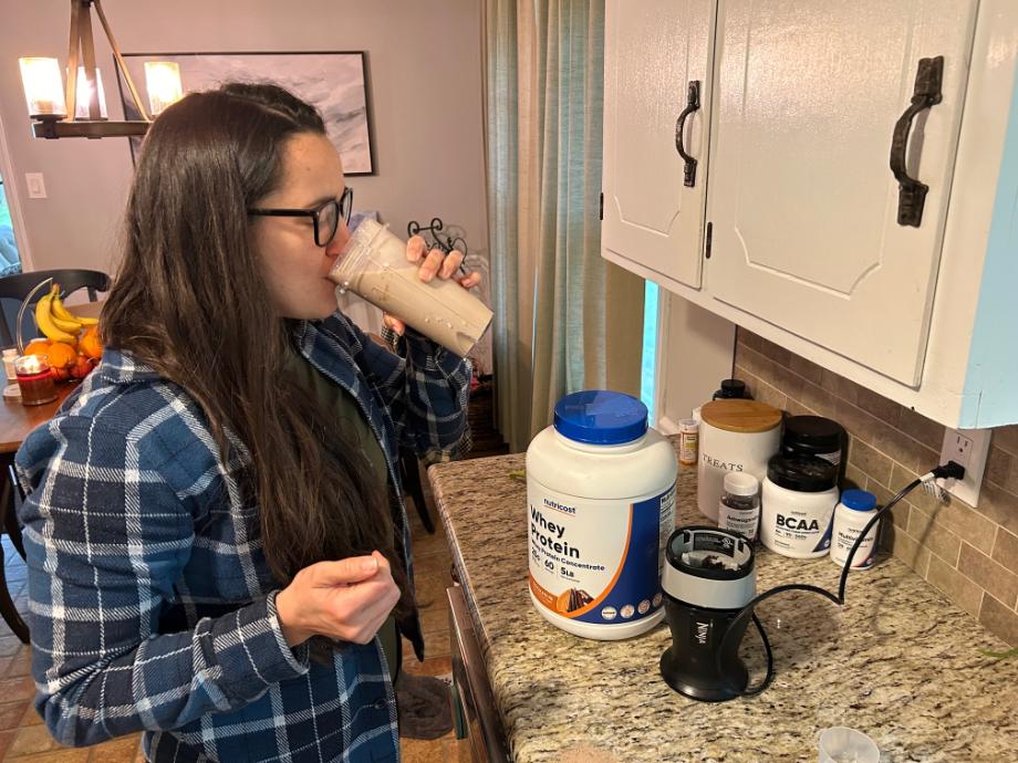 A woman drinking a Nutricost Whey Protein shake