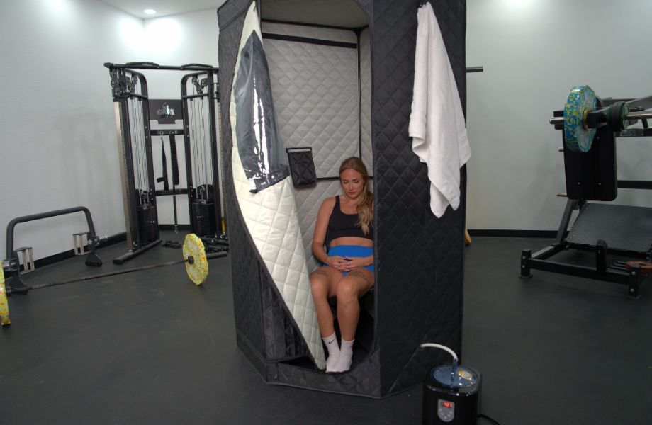 A woman sitting inside the SaunaBox SmartSteam Kit Pro